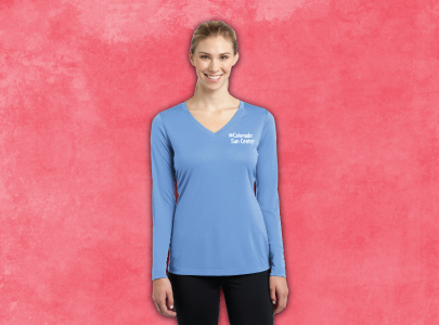 Woman wearing long sleeved, light blue, v neck t-shirt screen printed with Colorado Sun Center logo